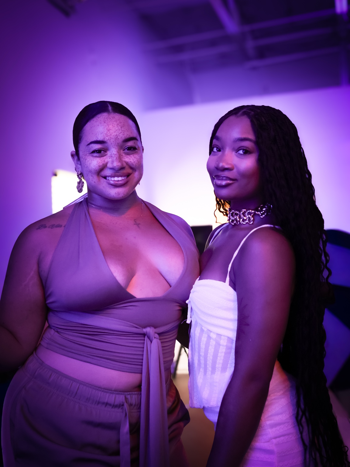 Two friends enjoying a ZOVA night under purple lighting